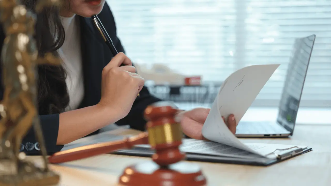 Competitive positioning for law practices — attorney reviewing legal documents at desk with gavel and Lady Justice statue