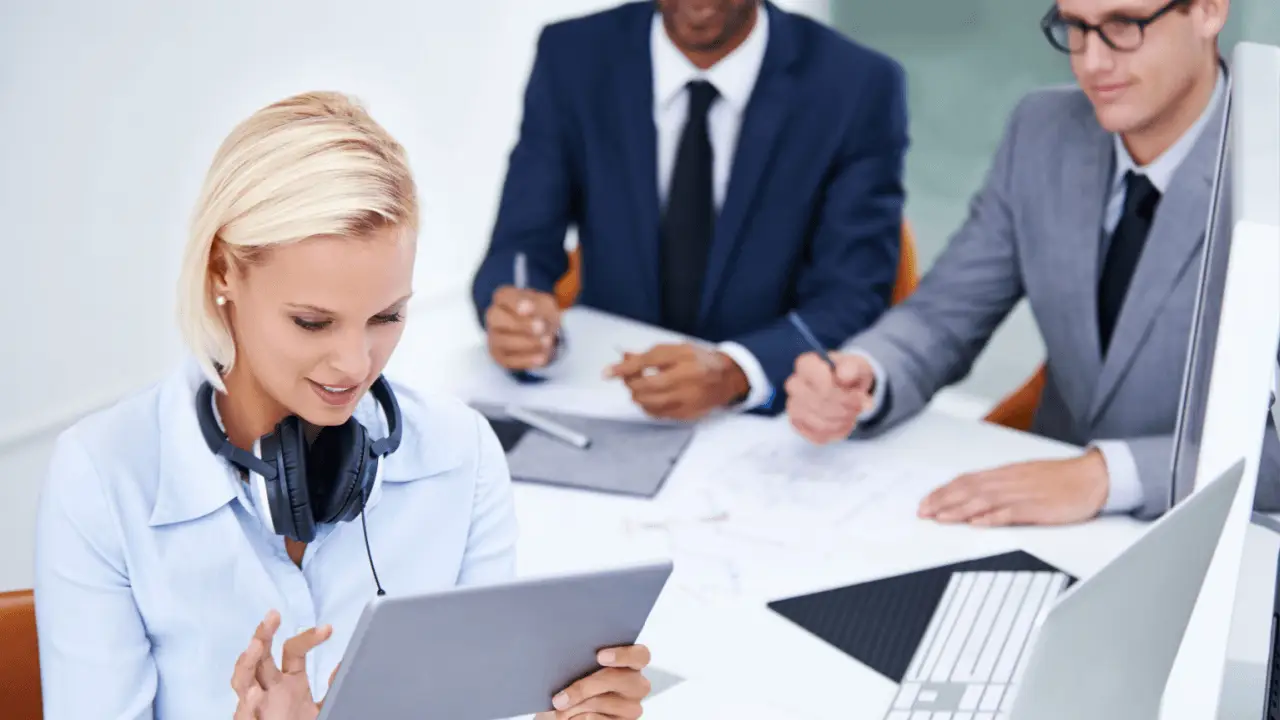 Attorneys reviewing strategic planning for legal services promotion on a tablet during a law firm marketing meeting