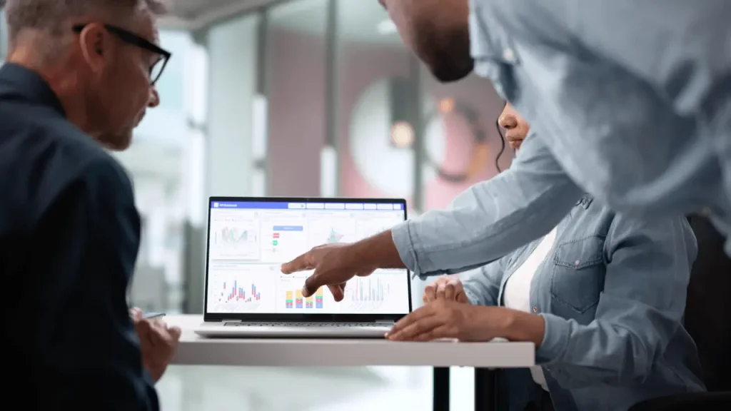 Marketing team reviewing law firm marketing analytics dashboard with charts and performance data on a laptop